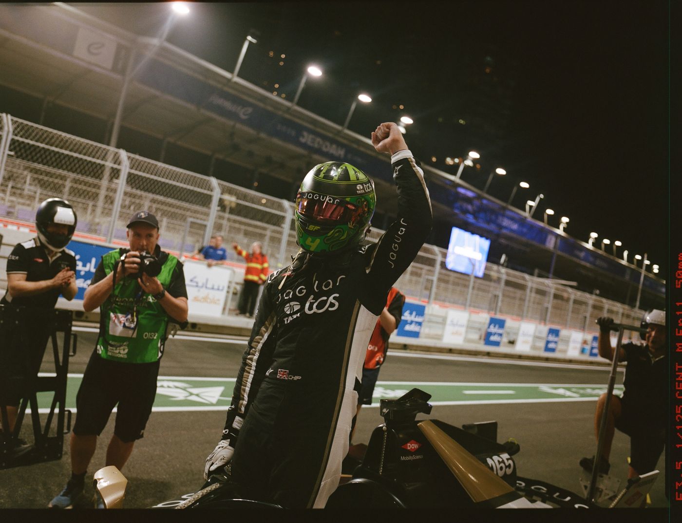 Race winner celebrating with a raised fist under the lights